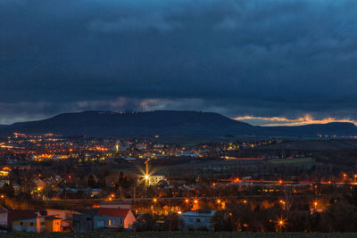 High angle view of illuminated city against sky at dusk