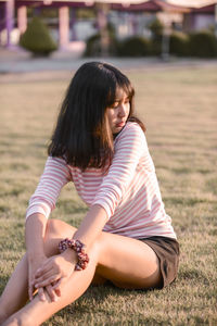 Young woman with arms raised on field