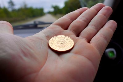 Cropped hand holding coin