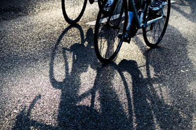 Low section of people riding bicycle on road