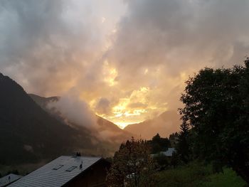 Panoramic view of buildings and mountains against sky during sunset