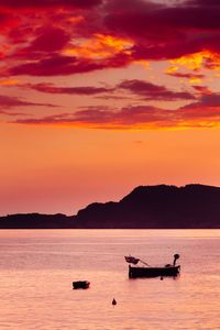 Silhouette boat in sea against sky during sunset