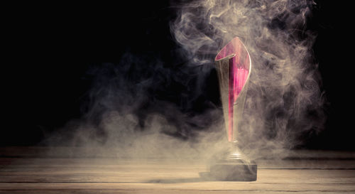 Smoke emitting from illuminated lighting equipment against black background