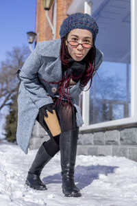 Portrait of young woman standing on snow