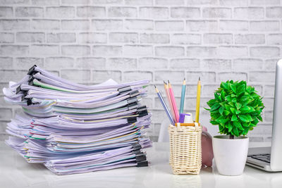 Stack of potted plants on table against wall