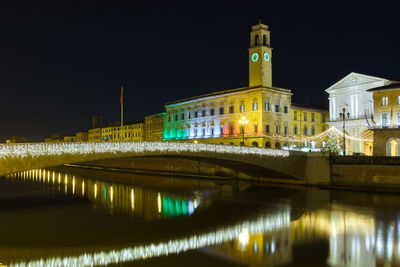 Illuminated bridge over river at night