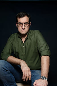 Portrait of man wearing hat against black background