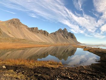 Scenic view of lake by mountains against sky