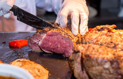 Close-up of man preparing food on barbecue grill