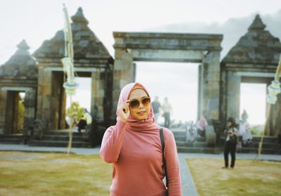 Woman wearing sunglasses standing outside temple
