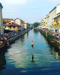 Man slacklining over river in city