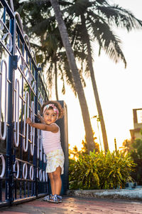 Full length of girl standing by gate