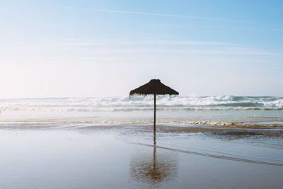 Lifeguard hut on beach against sky