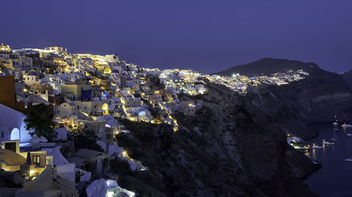 Illuminated cityscape against clear sky at night