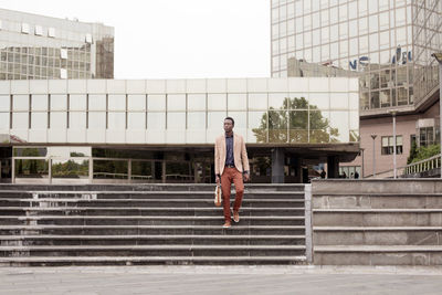 Businessman moving down steps in city