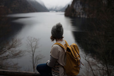 Rear view of woman sitting by königsee lake