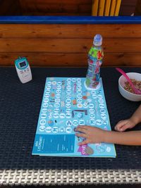 High angle view of woman holding text on table