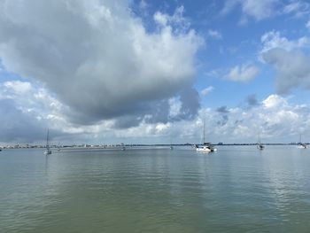 Sailboats in sea against sky