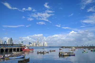 Boats in sea against cloudy sky