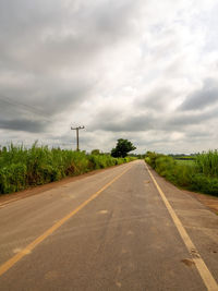 View of country road against cloudy sky