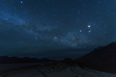 Scenic view of mountains against sky at night