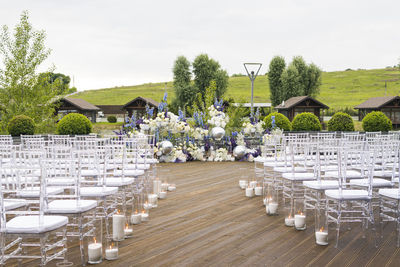 Chairs and tables in front of building against sky