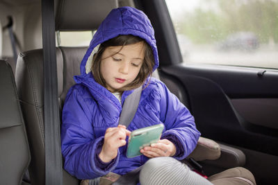 Full length of girl sitting in car