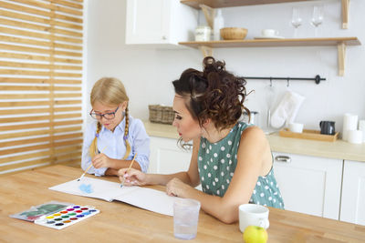 Mother and daughter painting at home