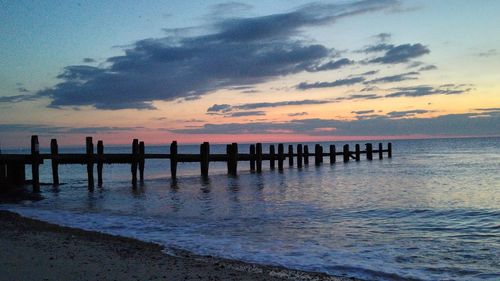 Pier on sea at sunset