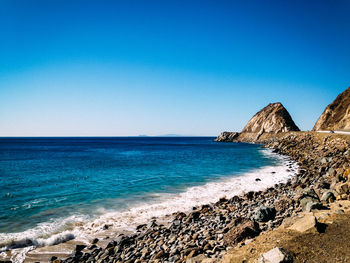 Scenic view of beach against blue sky