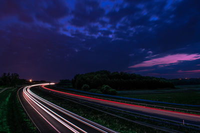 High angle view of light trails on road against sky at night