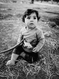 Cute baby girl sitting on land