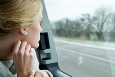 Close-up of woman looking through window