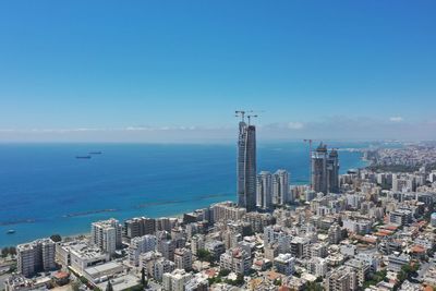 Aerial view of city by sea against clear sky