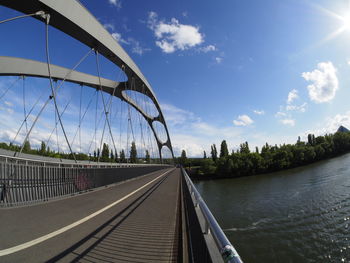 Bridge over river against sky in city