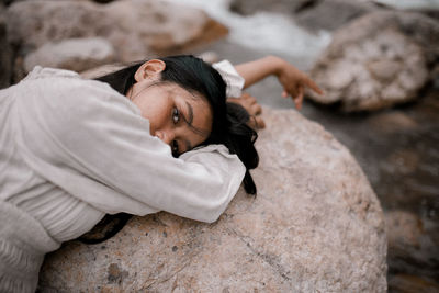 High angle view of man lying on rock