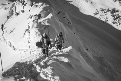 Men with snowboards walking on mountain