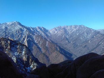 Scenic view of snowcapped mountains against clear blue sky