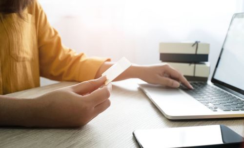 Midsection of woman using laptop on table