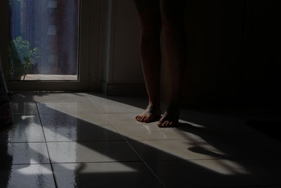 Low section of man standing on floor at home