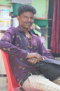 Portrait of young man sitting on chair