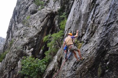 Low angle view of man standing on cliff