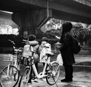 Rear view of people on bicycle in city