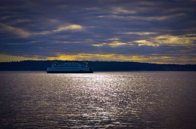 Scenic view of sea against cloudy sky at sunset