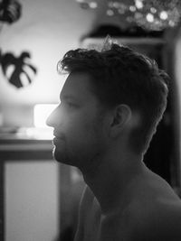 Close-up of young man looking through window