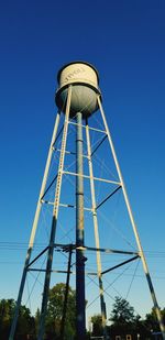 Low angle view of water tower against clear blue sky