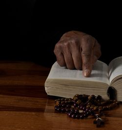 Cropped hand of person holding coffee beans on table