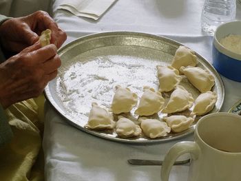 Cropped image of hand making pierogi in kitchen