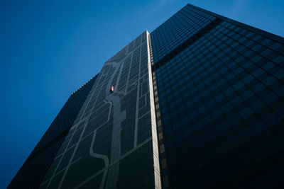 Low angle view of modern building against clear blue sky