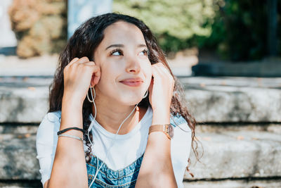 Portrait of young woman looking away outdoors